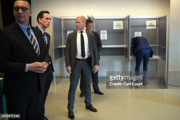 Close protection police officers surround Geert Wilders , the leader of the right-wing Party for Freedom , as he casts his vote during the Dutch...