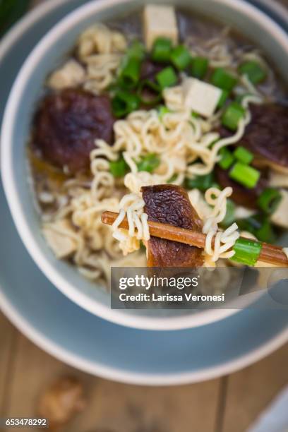 bowl of miso ramen soup with organic tofu, shitake mushrooms and spring onions on dark wood - miso stock-fotos und bilder