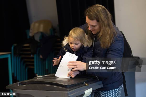 Child helps a woman to cast her vote in the Dutch general election, on March 15, 2017 in The Hague, Netherlands. Dutch voters go to the polls today...