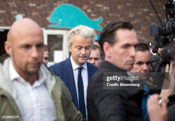 Geert Wilders, leader of the Dutch Freedom Party , center, is surrounded by members of his security as he departs after casting his vote in the Dutch...