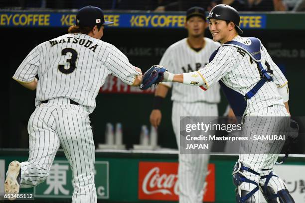 Infielder Nobuhiro Matsuda high fives with Catcher Seiji Kobayashi after the top of the second inning during the World Baseball Classic Pool E Game...