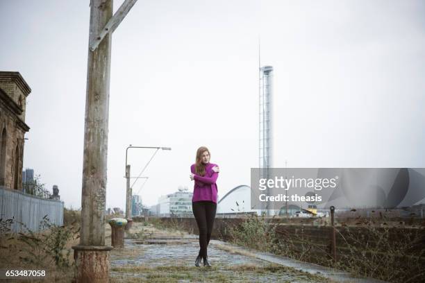 attraente giovane donna al abbandonato glasgow docks - theasis foto e immagini stock
