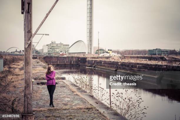 attraktive junge frau an verfallenen glasgow docks - theasis stock-fotos und bilder