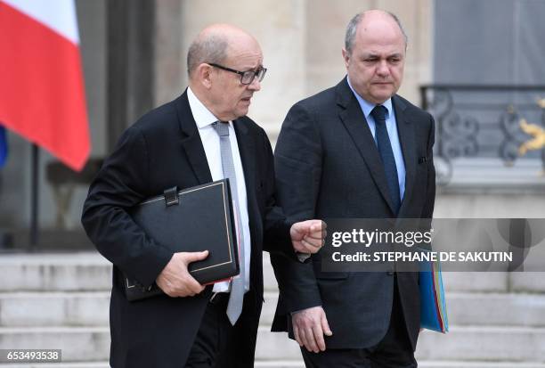 French Defence Minister Jean-Yves Le Drian and French Interior Minister Bruno Le Roux leave following a cabinet meeting or Conseil des ministres at...