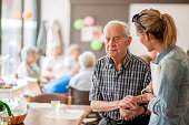 Assistant In The Community Center Giving Advice To A Senior Man