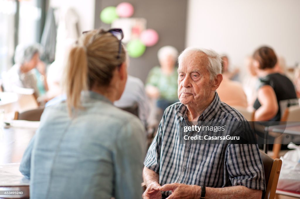 Adjoint au centre communautaire donnant des conseils  à un homme Senior