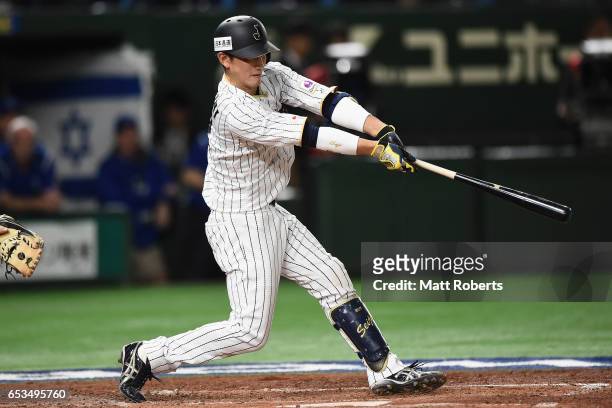 Catcher Seiji Kobayashi of Japan flies out in the bottom of the fourth inning during the World Baseball Classic Pool E Game Six between Israel and...