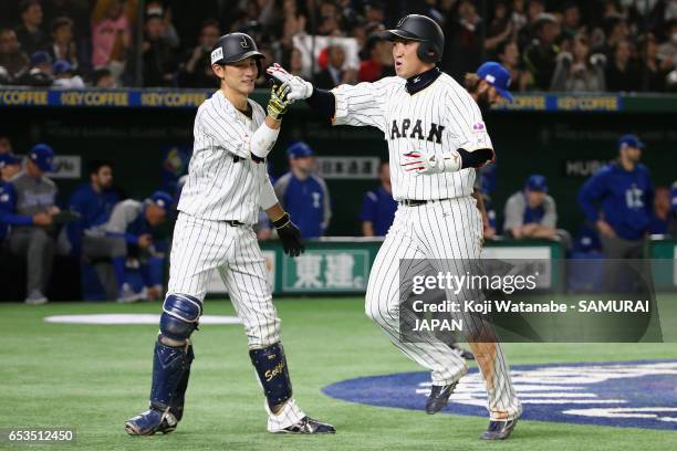 Outfielder Seiichi Uchikawa of Japan celebrates with Catcher Seiji Kobayashi after scoring a run by a RBI single of Infielder Nobuhiro Matsuda to...