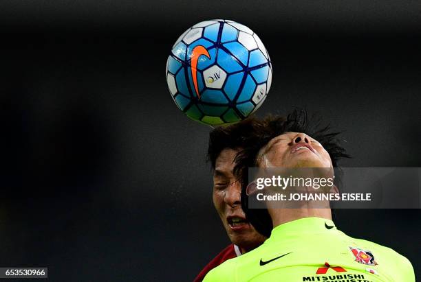 Shanghai SIPG defender Zhang Wei and Urawa Red Diamonds forward Tadanari Lee fight for the ball during the AFC Asian Champions League group match...