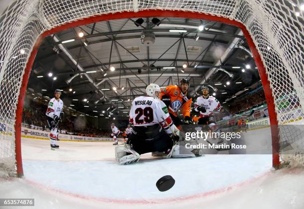 Nick Johnson of Wolfsburg scores the opening goal over Gustaf Wesslau, goaltender of Koeln during the DEL Playoffs quarter finals Game 4 between...