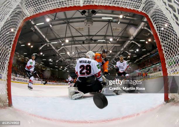 Nick Johnson of Wolfsburg scores the opening goal over Gustaf Wesslau, goaltender of Koeln during the DEL Playoffs quarter finals Game 4 between...