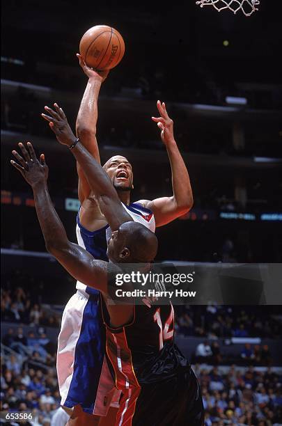 Sean Rooks of the Los Angeles Clippers shoots the ball against Anthony Mason of the Miami Heat during the game at the STAPLES Center in Los Angeles,...