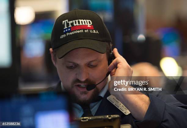 Trader wearing a Trump hat works on the floor before the closing bell of the Dow Jones at the New York Stock Exchange, March 15, 2017 in New York. US...