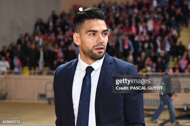 Monaco's injured Colombian forward Radamel Falcao arrives on the pitch to celebrate with teammates at the end of the UEFA Champions League round of...
