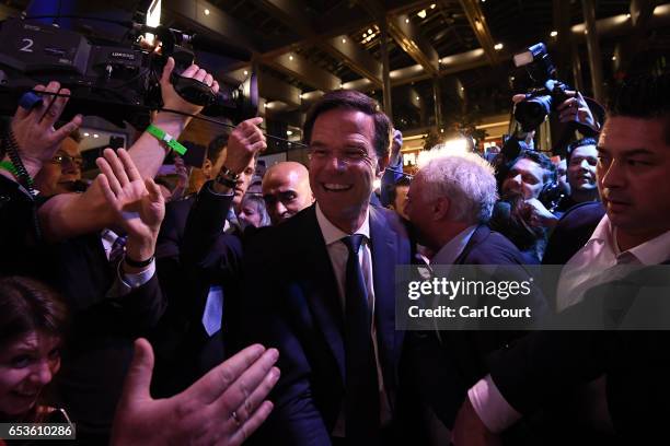 Dutch Prime Minister Mark Rutte is greeted by supporters as he arrives to make a speech following his victory in the Dutch general election on March...