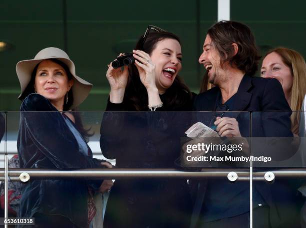 Sadie Frost, Liv Tyler and Darren Strowger watch the racing as they attend day 2 'Ladies Day' of the Cheltenham Festival at Cheltenham Racecourse on...