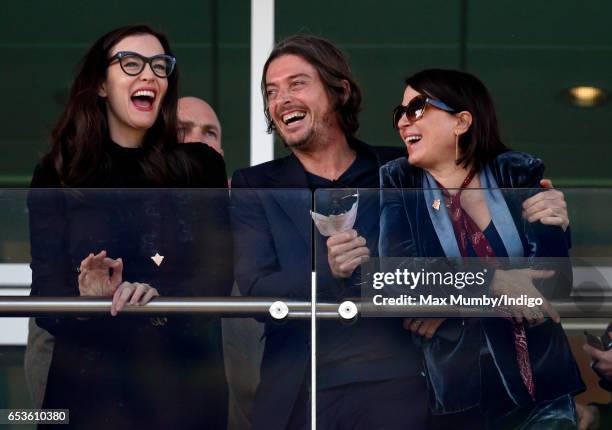 Liv Tyler, Darren Strowger and Sadie Frost watch the racing as they attend day 2 'Ladies Day' of the Cheltenham Festival at Cheltenham Racecourse on...