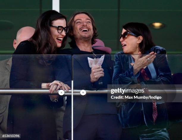 Liv Tyler, Darren Strowger and Sadie Frost watch the racing as they attend day 2 'Ladies Day' of the Cheltenham Festival at Cheltenham Racecourse on...