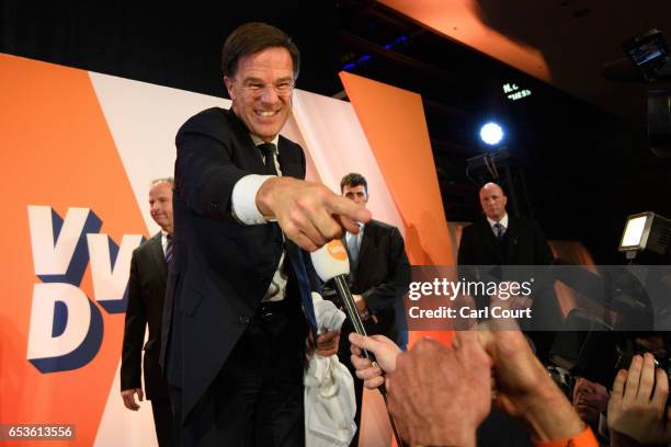 Dutch Prime Minister Mark Rutte gestures to a supporter after making a speech following his victory in the Dutch general election on March 15, 2017...