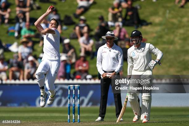 Morne Morkell of South Africa bowls while umpire Rod Tucker of Australia and Henry Nicholls of New Zealand look on during day one of the Test match...