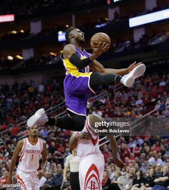 David Nwaba of the Los Angeles Lakers drives past James Harden of the Houston Rockets and Trevor Ariza during the fourth quarter at Toyota Center on...