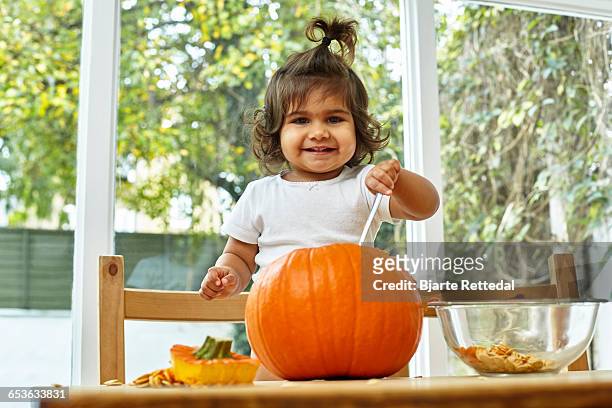 baby girl carving a pumpkin - bjarte rettedal stock pictures, royalty-free photos & images