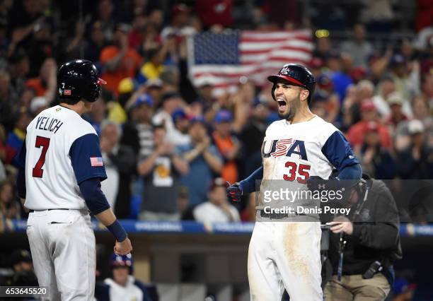 Eric Hosmer of the United States, center, celebrates with Christian Yelich after hitting a two-run home run in the eighth inning of the World...