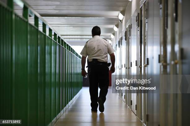 Prison guard walks through a cell area at HMP Berwyn on March 15, 2017 in Wrexham, Wales. The mainly category C prison is one of the biggest jails in...