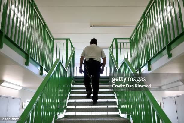 Prison guard walks through a cell area at HMP Berwyn on March 15, 2017 in Wrexham, Wales. The mainly category C prison is one of the biggest jails in...