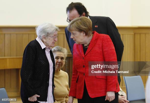 German Chancellor Angela Merkel and Father Martin von Essen speak with as senior citizens in the dance hall at the Paul-Gerhadt-Stift center on March...