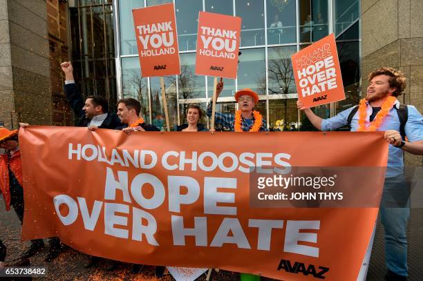 Members of campaign group Avaaz welcome the victory of the Liberal VVD party in the general elections, at the Buitenhof entrance of the Dutch...