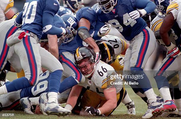 Alan Faneca of the Pittsburgh Steelers get piled on as he is choked by his helmet during the game against the New York Giants at the Giants Stadium...