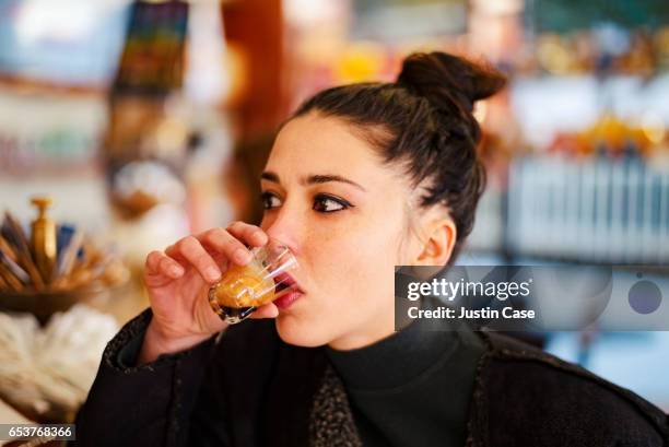 woman zipping an espresso in a coffee bar - espresso stock-fotos und bilder