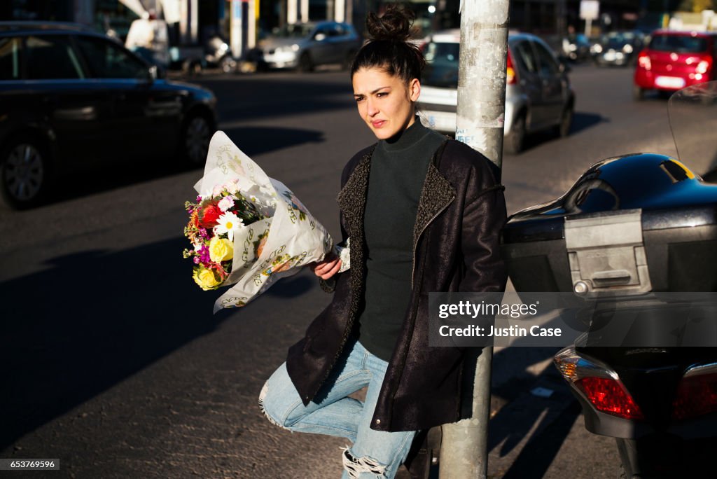 Woman waitingwith a bunch of flowers in her hand