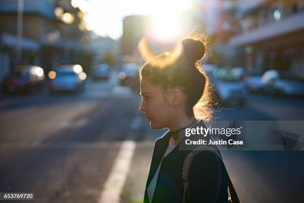 woman crossing a street - topknot stock-fotos und bilder