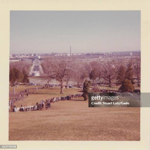 People wait in a long line in order to visit the grave of assassinated United States President John F Kennedy shortly after his death, at Arlington...