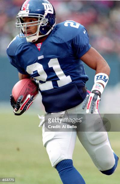 Tiki Barber of the New York Giants carries the ball up the field during the game against the Pittsburgh Steelers at the Giants Stadium in East...