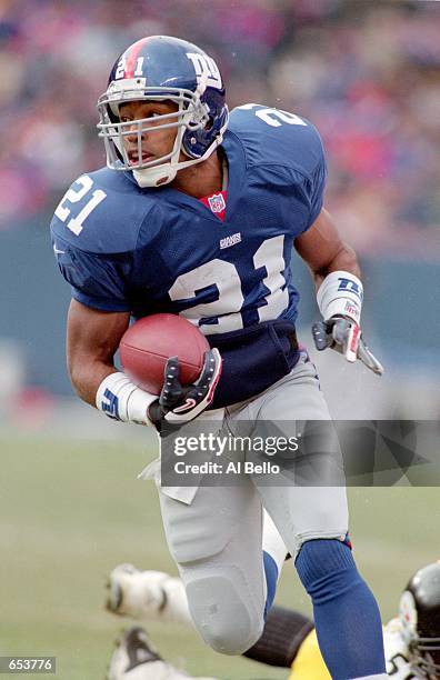 Tiki Barber of the New York Giants carries the ball up the field during the game against the Pittsburgh Steelers at the Giants Stadium in East...