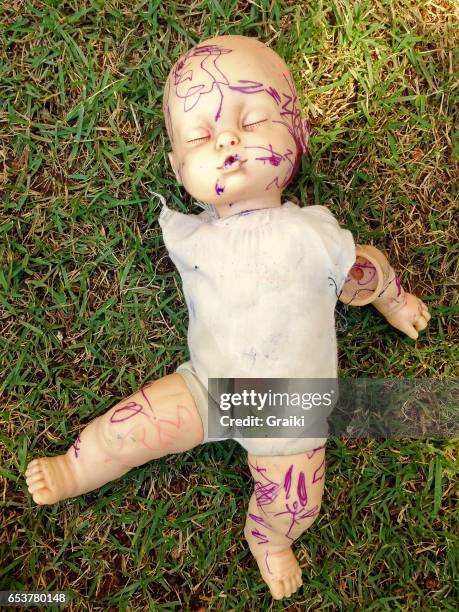 broken doll in the grass - bambola giocattolo foto e immagini stock