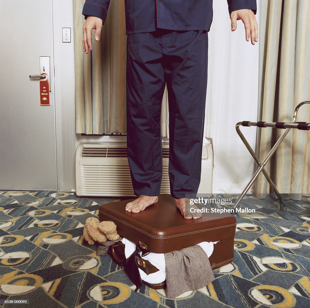 Man Standing on Suitcase