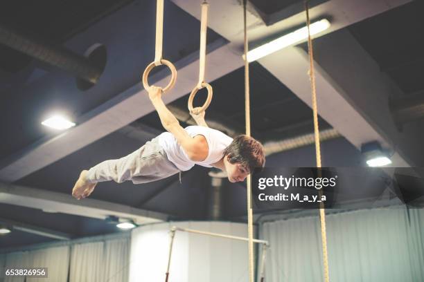exercising on gymnastic rings - gymnastics equipment stock pictures, royalty-free photos & images