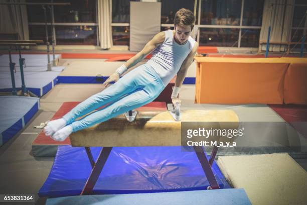 exercising on pommel horse. - gymnastics stock pictures, royalty-free photos & images