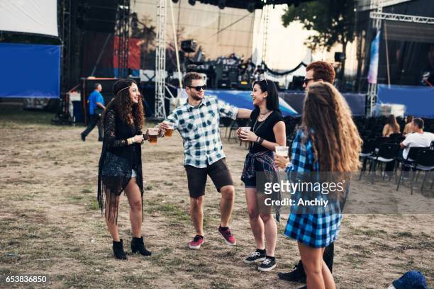 happy teenagers dancing in front of the stage at the music festival - music festival field stock pictures, royalty-free photos & images