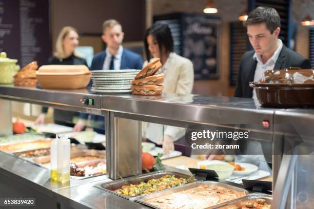 people in canteen waiting in line - self service stock pictures, royalty-free photos & images