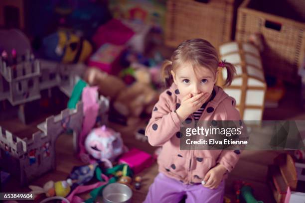 child with surprised expression, in a messy bedroom - guilt stock pictures, royalty-free photos & images