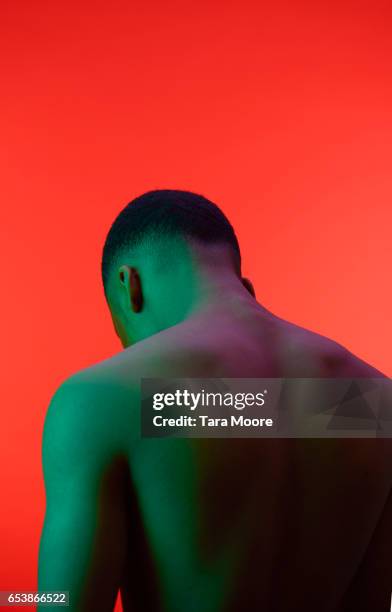 back of green man on red background - green man red man stock pictures, royalty-free photos & images