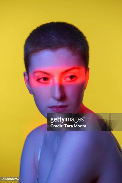 woman with red light on eyes - androgyn stock pictures, royalty-free photos & images