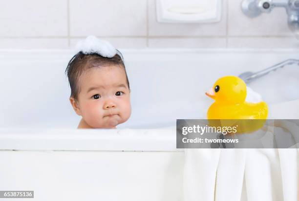 asian baby boy in bathtub. - gummiente stock-fotos und bilder