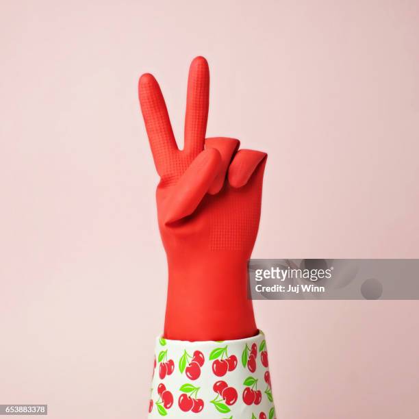 hand in red rubber glove making peace sign - red glove stockfoto's en -beelden