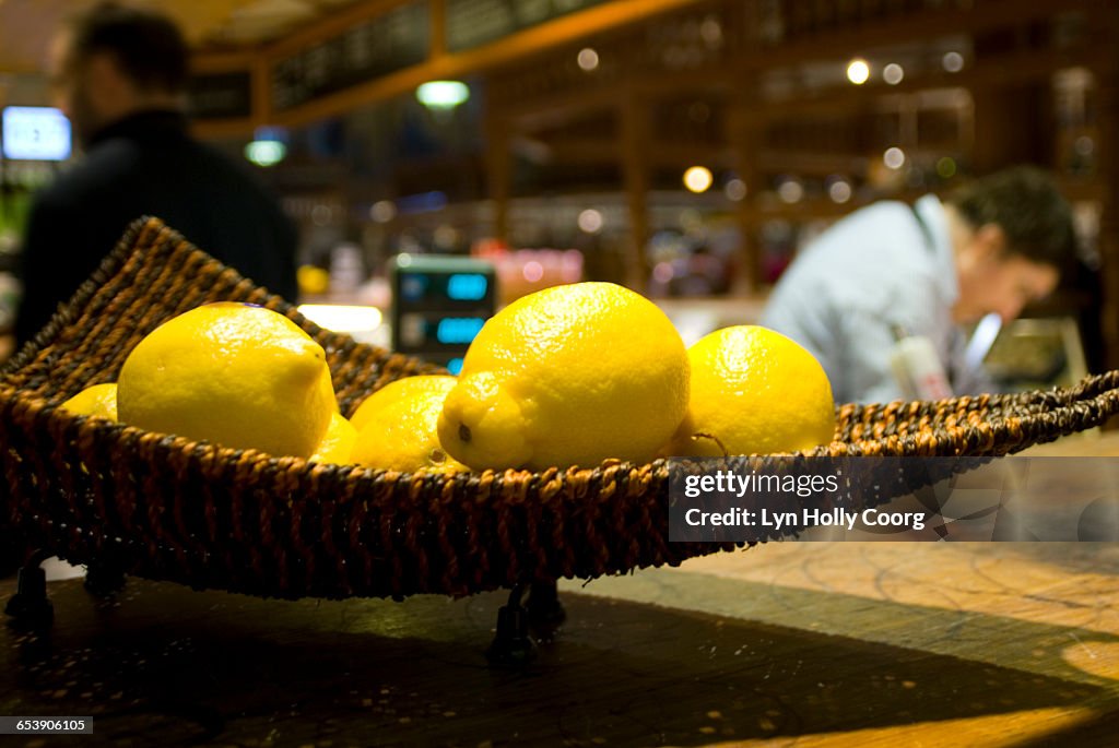 Close up of fresh lemons in bar with bar staff